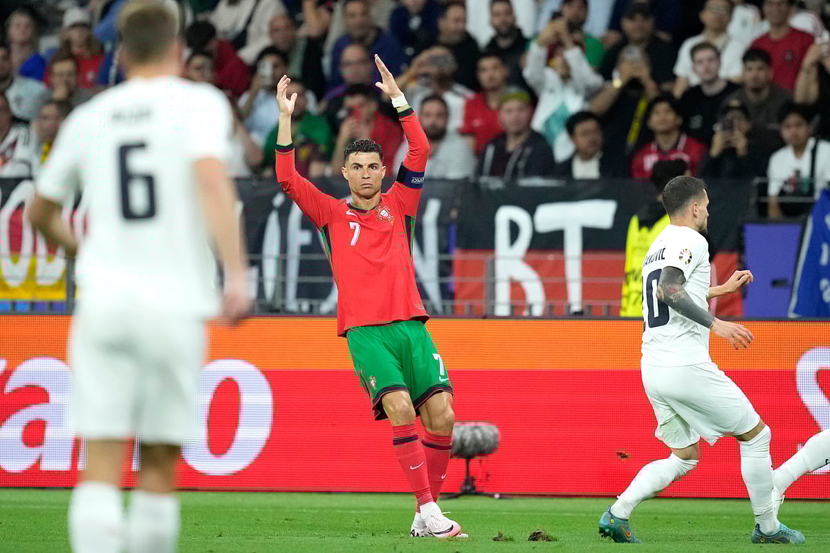 (AP Photo/Michael Probst) : Portugal's Cristiano Ronaldo, right, reacts during a round of sixteen match between Portugal and Slovenia at the Euro 2024 soccer tournament in Frankfurt, Germany, Monday, July 1, 2024. 