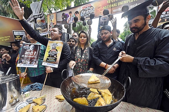 Getty Images : Indian Youth Congress members symbolically run a snacks shop as they observe Prime Minister Narendra Modi's birthday as National Unemployment Day