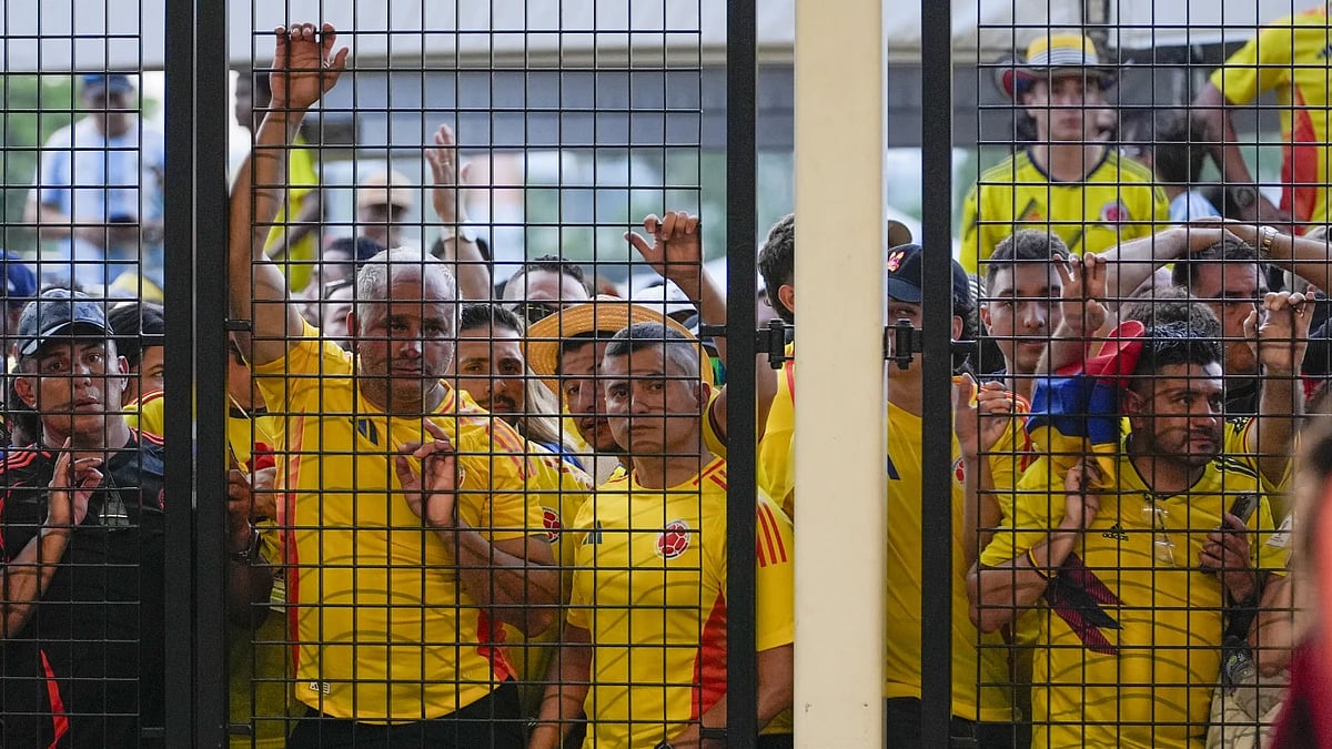 AP : Colombian fans watch on from the security gates at the Hard Rock Stadium.