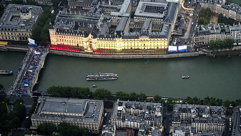 Boats carrying athletes float along the river Seine past the Concergerie in Paris, France, during the opening ceremony for the 2024 Summer Olympics, Friday, July 26, 2024. - Lionel Bonaventure/Pool Photo via AP