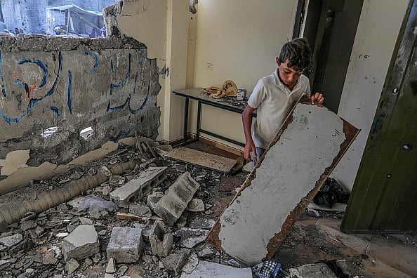 Getty Images : Palestinians investigate the heavily damaged Al-Awda school building following the Israeli attack in Abasan district of Khan Yunis, Gaza on July 10, 2024. 