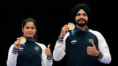 India's Manu Bhaker, left, and Sarabjot Singh pose for a photograph after winning the bronze medal in the 10m air pistol mixed team event at the 2024 Summer Olympics, Tuesday, July 30, 2024, in Chateauroux, France
