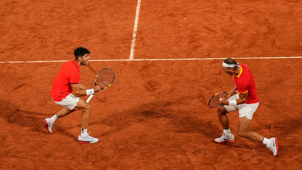 AP/Manu Fernandez : Carlos Alcaraz, left, and Rafael Nadal from the Spanish team celebrate a point during the men's doubles tennis.