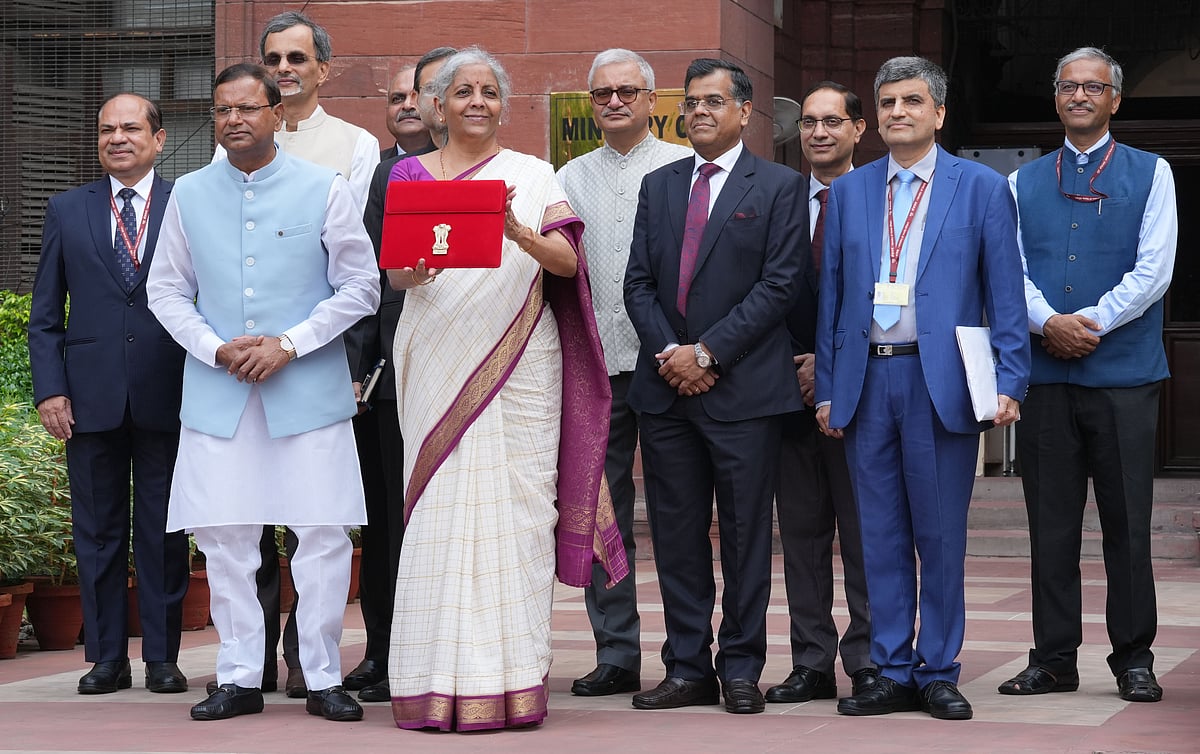 Tribhuvan Tiwari : Union Finance Minister Nirmala Sitharaman displays a red pouch carrying the Budget documents outside the Finance Ministry