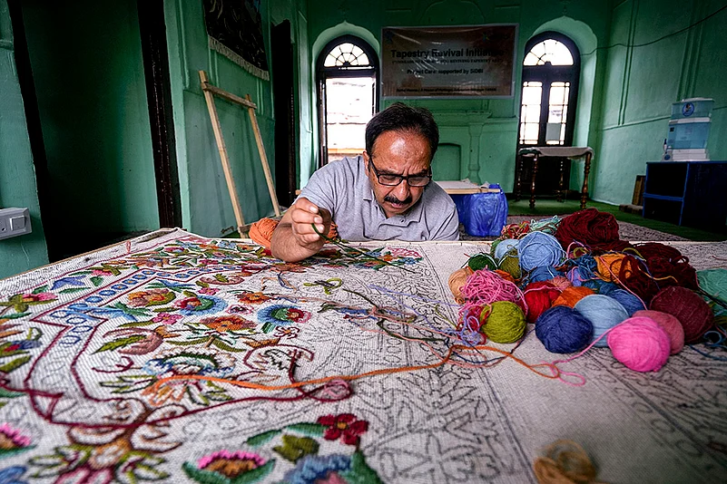 Artisan works on a tapestry handicraft, in Srinagar, in Jammu and Kashmir