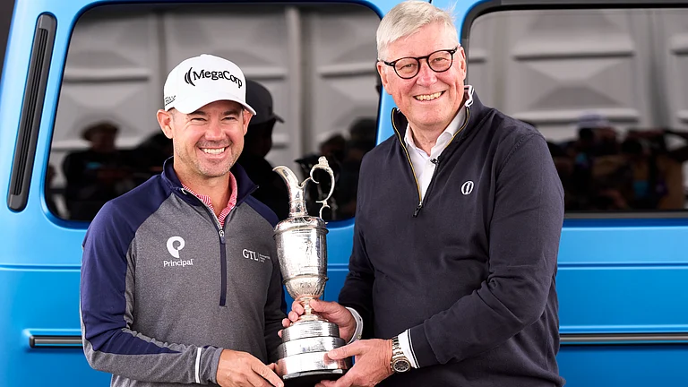 Brian Harman (L) hands back the Claret Jug at Royal Troon on Monday. - null