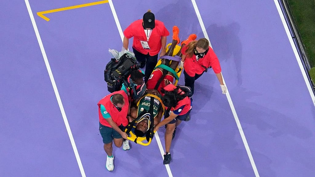 AP/David J. Phillip : Lamecha Girma, of Ethiopia, is taken off the track by medical staff after falling during the men's 3,000 steeplechase final at the 2024 Summer Olympics, Wednesday, Aug. 7, 2024, in Saint-Denis, France.