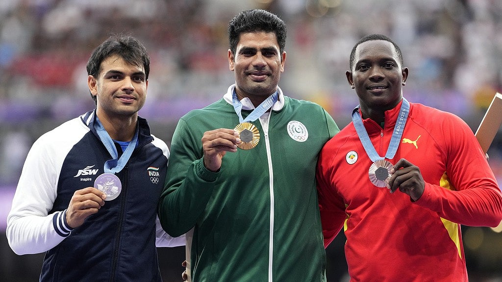 AP : Men's javelin gold medallist, Arshad Nadeem, centre, of Pakistan, stands with silver medalist, Neeraj Chopra, of India, and bronze medalist, Anderson Peters, right, of Grenada, on the podium at the Paris Olympics.