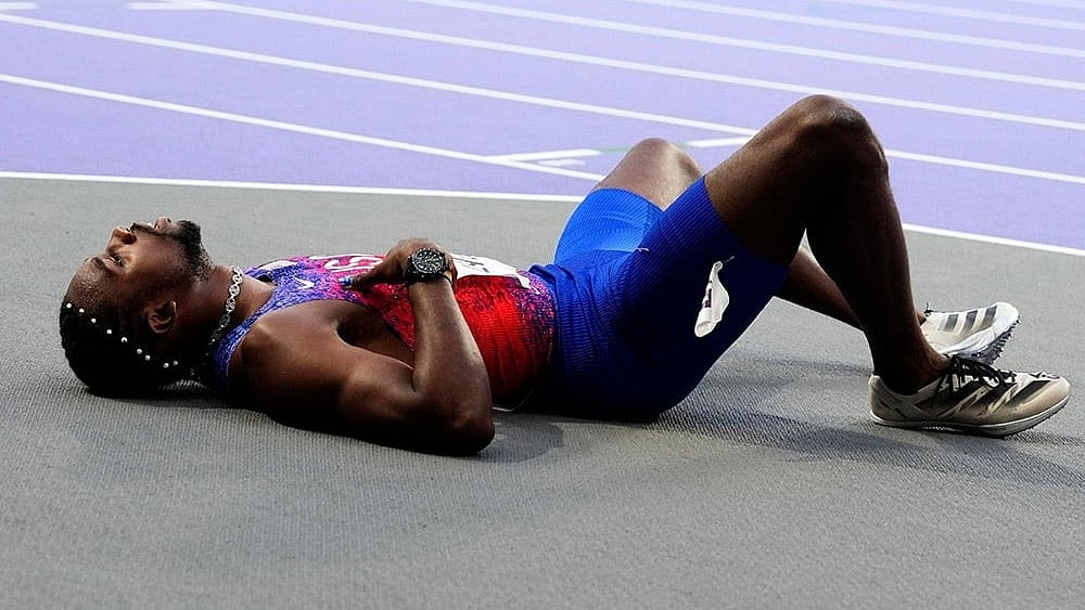 | Photo: AP/Petr David Josek : Noah Lyles, of the United States, lies on the track following the men's 200-meters final