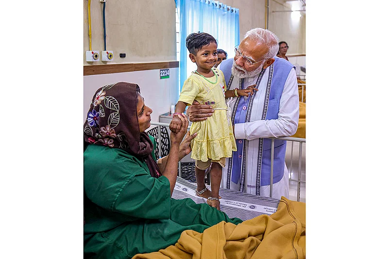 PM Modi Modi interacts with a child affected by the landslide, at a Hospital in Wayanad