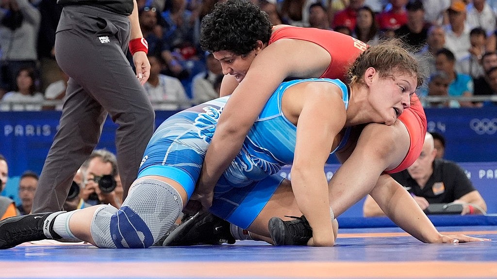 AP/Eugene Hoshiko : India's Reetika Hooda and Hungary's Bernadett Nagy, in blue, compete in the round of 16 of the women's freestyle 76kg wrestling match, at Champ-de-Mars Arena.