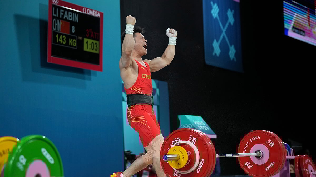 AP Photo/Kin Cheung : Li Fabin of China reacts as he competes during the men's 61kg weightlifting event at the 2024 Summer Olympics.