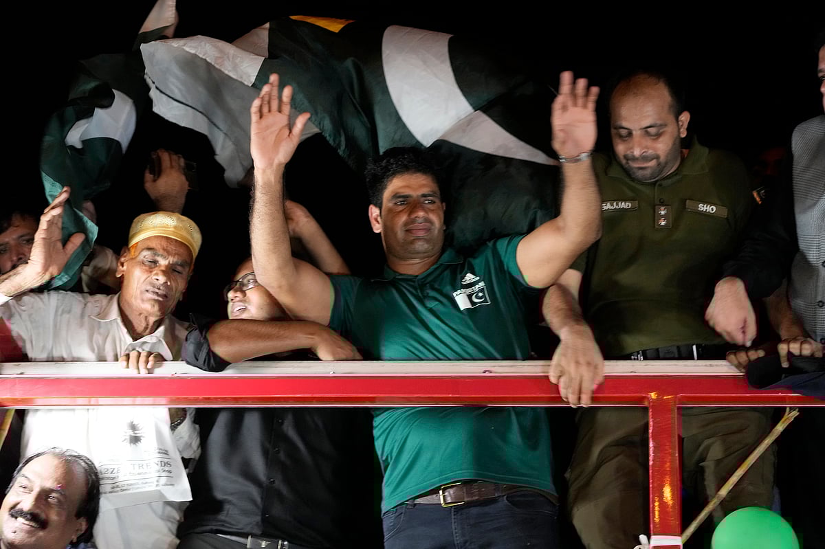 (AP Photo/K.M. Chaudary) : Men's javelin gold medalist, Arshad Nadeem, of Pakistan, centre, waves to Pakistani people outside the Allama Iqbal International Airport, Lahore during his arriving, in Lahore, Pakistan, Sunday, Aug. 11, 2024. 
