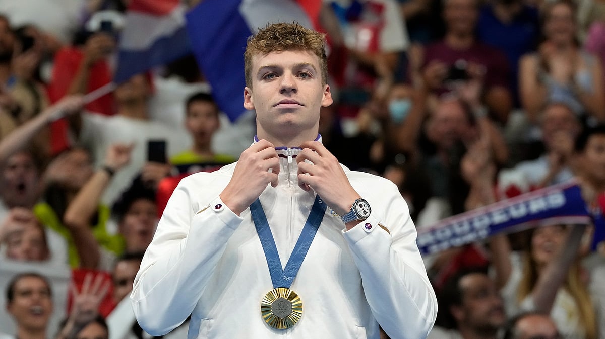 AP Photo/Natacha Pisarenko : Leon Marchand of France reacts after receiving his gold medal for the men's 200-meter individual medley final at the 2024 Summer Olympics.