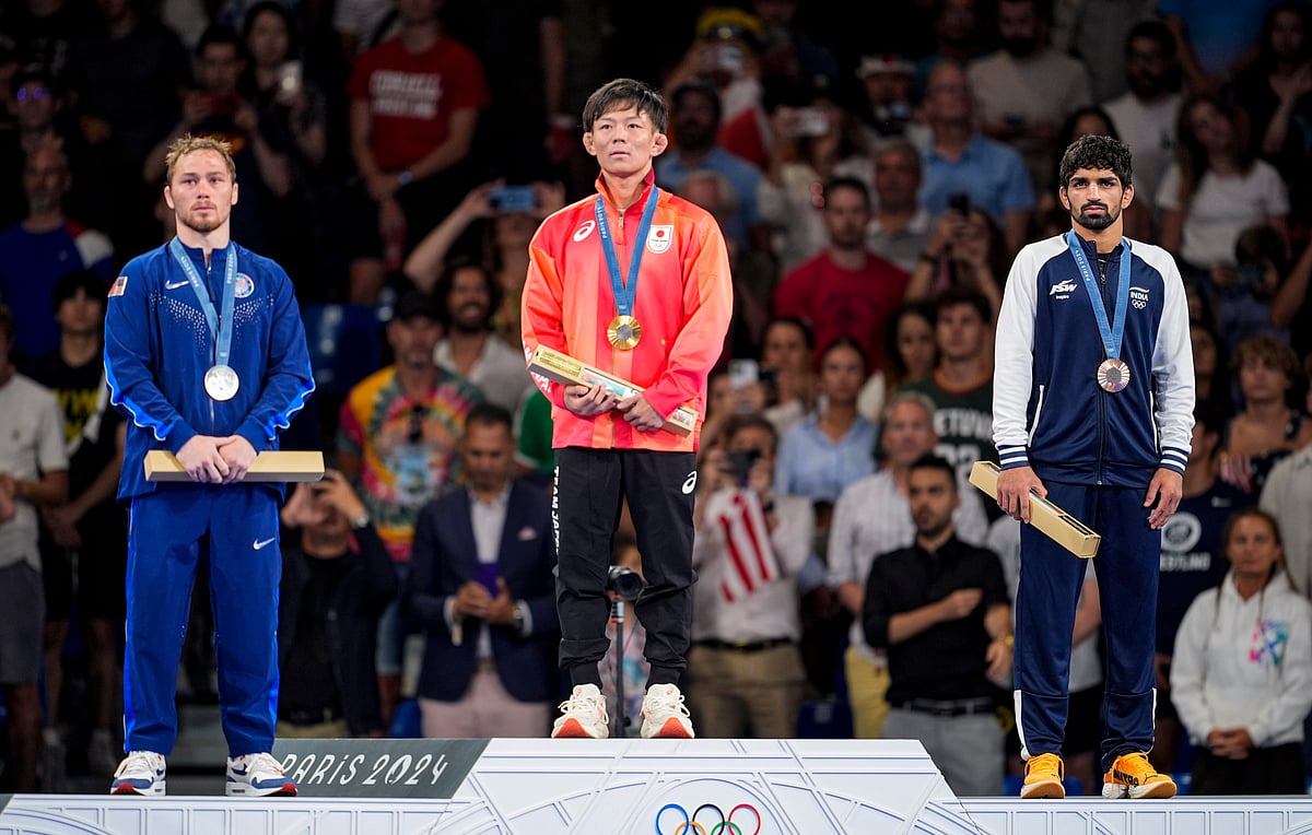  (PTI Photo/Ravi Choudhary) : Bronze medalist India's Aman Sehrawat (R) pose for photos at the podium during the victory ceremony