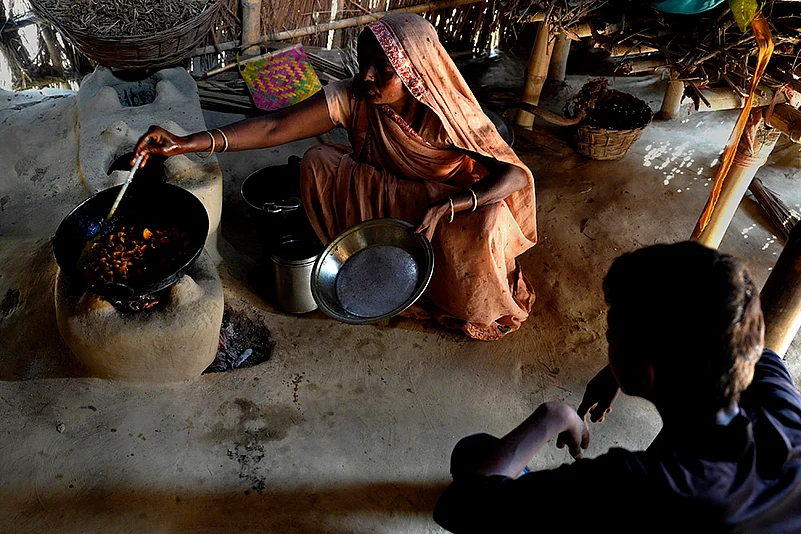 Deepak’s mother cooking food at their mud house