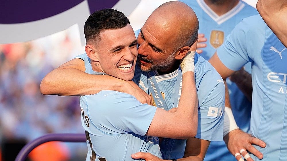 Manchester City's head coach Pep Guardiola with Phil Foden (left) - Photo: AP/Dave Thompson