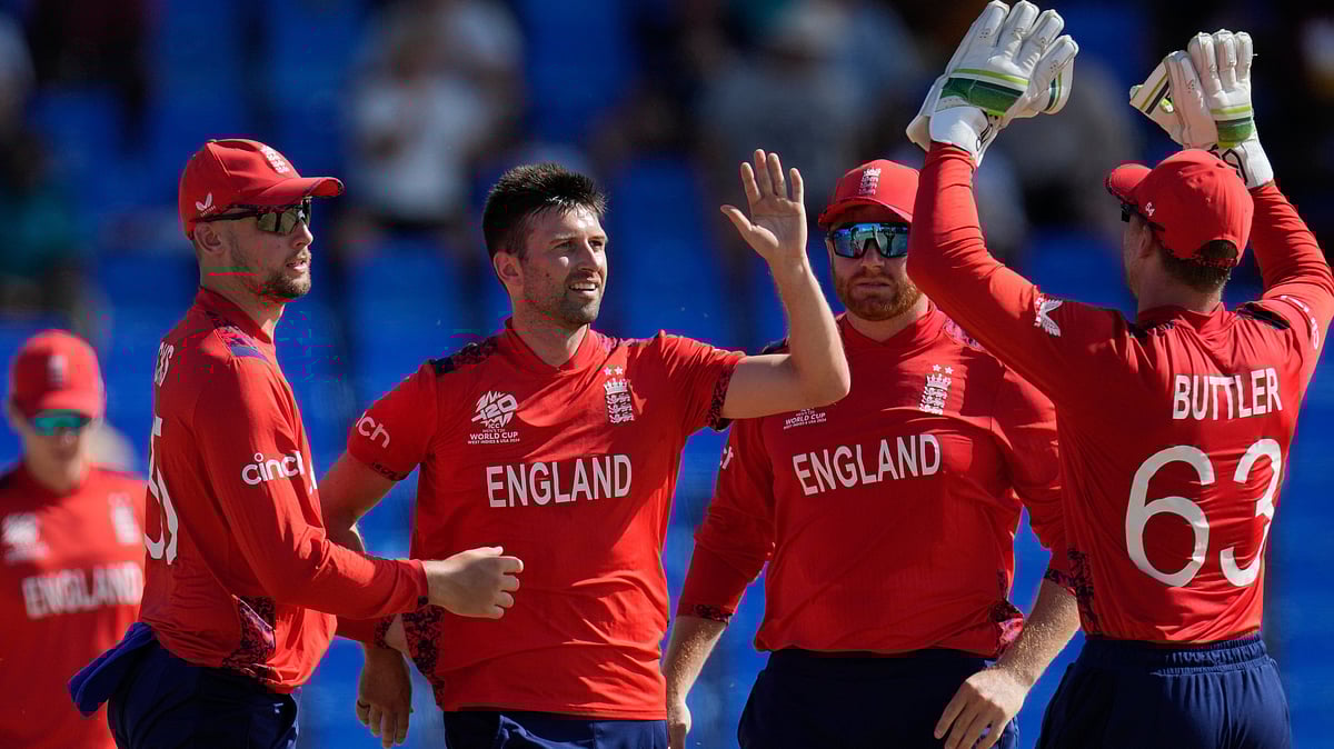 Englands Mark Wood highs five with teammates after taking the wicket