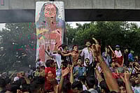 AP Photo : Protesters celebrate beside a defaced portrait of Prime Minister Sheikh Hasina after news of her resignation |