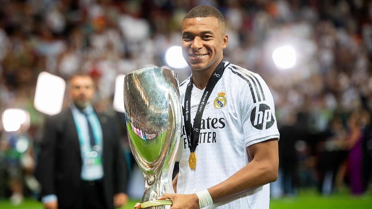 Kylian Mbappe poses with the UEFA Super Cup trophy. - null