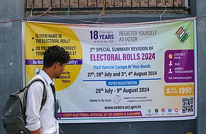 (Photo by Firdous Nazir/NurPhoto via Getty Images) : A student is looking at the Election banner as he is walking along a road in Srinagar, Jammu and Kashmir, on August 07, 2024.