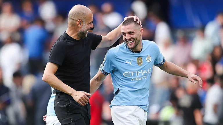 Pep Guardiola (left) and Mateo Kovacic celebrate Sunday's 2-0 victory at Stamford Bridge. - null