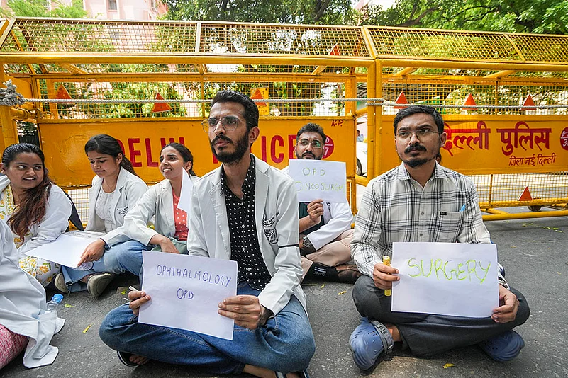 Doctors display placards offering OPD facility during a protest at Nirman Bhawan in New Delhi