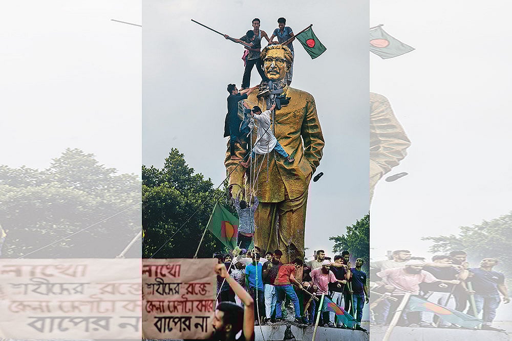 Photo: Getty Images : Bring it Down: Protestors climbing a statue of Sheikh Mujibur Rahman in Dhaka