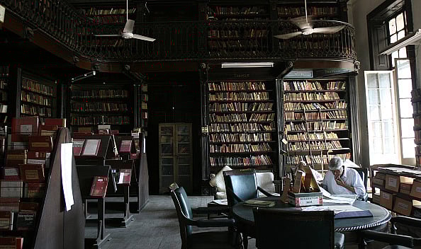 Lost in the sea of books - A man surfs through the books in National Library Bandra - Getty Images