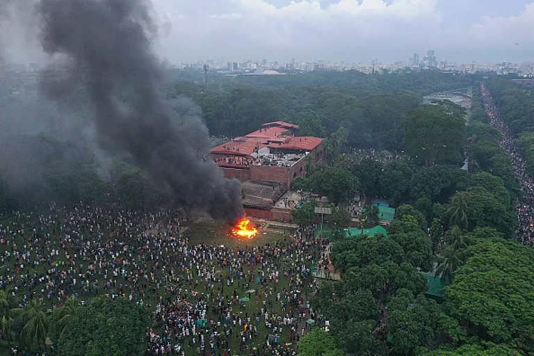 In this aerial view, fires burn outside the Prime Minister's House after Bangladesh Prime Minister Sheikh Hasina resigned and fled the country. - Drik