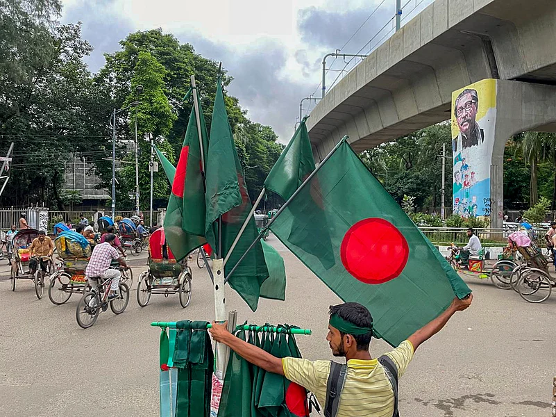 Dhaka: A flag-seller stands on the periphery of a memorial site Dhaka: A flag-seller stands on the periphery of a memorial site