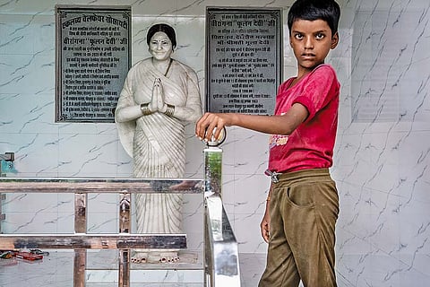 Phoolan’s nephew Nishant standing next to a statue of his aunt at the house where she was born