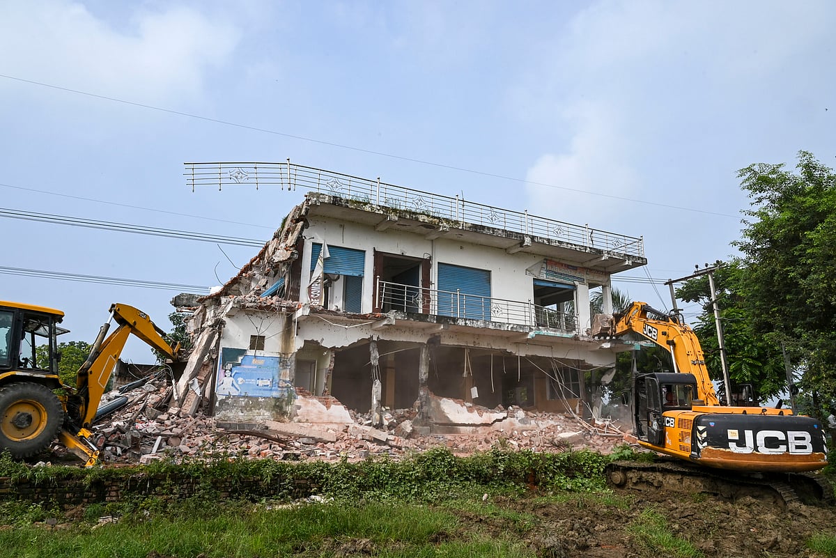 - : An excavator being used to demolish an illegal shopping complex owned by Moid Khan, an accused in a gang rape case, in Ayodhya.
