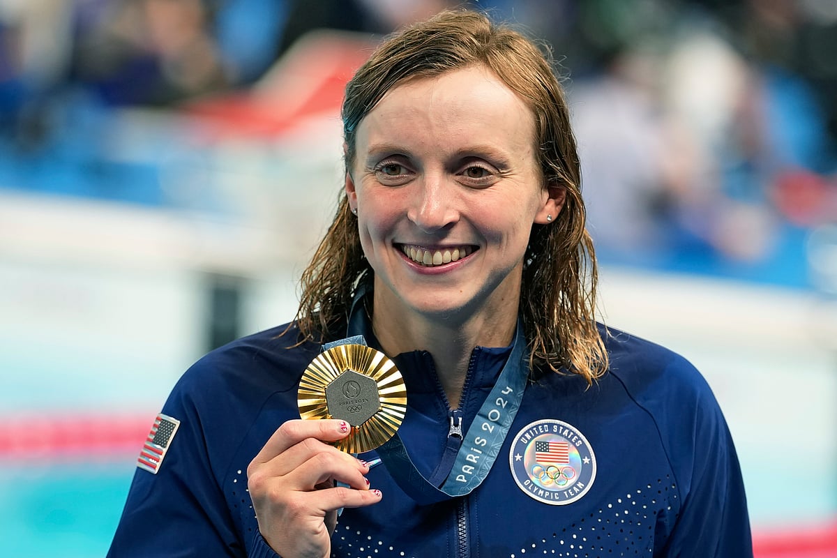 (AP Photo/Brynn Anderson) : United States' Katie Ledecky celebrates with the gold medal during the awards ceremony for the women's 800-meter freestyle at the Summer Olympics in Nanterre, France, Saturday, Aug. 3, 2024. 