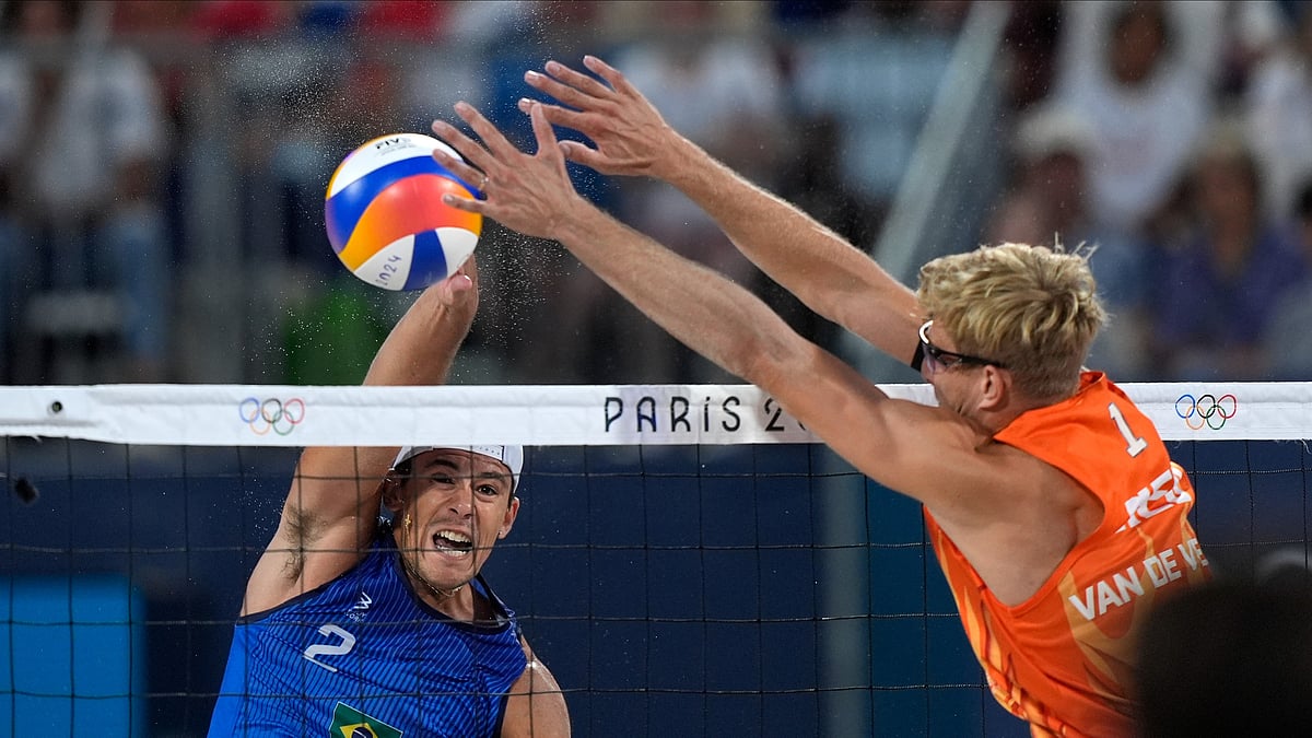 AP Photo/Robert F. Bukaty : Brazil's Arthur Diego Mariano Lanci smashes the ball by Netherland's Steven van de Velde in a beach volleyball match at the 2024 Summer Olympics.