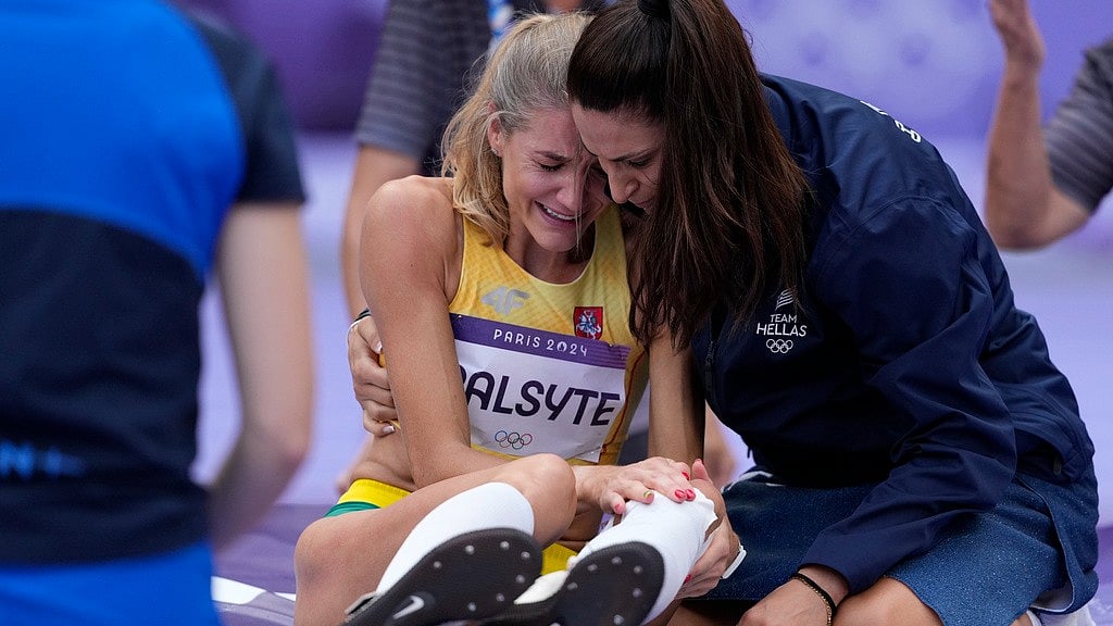 AP/Bernat Armangue : Tatiana Gusin, of Greece,, right, tries to comfort Airine Palsyte, of Lithuania, after she got injured injured during the women's high jump qualification at the 2024 Summer Olympics, Friday, Aug. 2, 2024, in Saint-Denis, France.