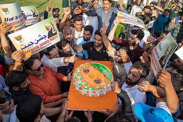 Supporters of Narendra Modi, India's Prime Minister and leader of the Bharatiya Janata Party (BJP), seen holding a cake as they celebrate vote-counting results for India's general election.  - Photo by Faisal Bashir via Getty Images