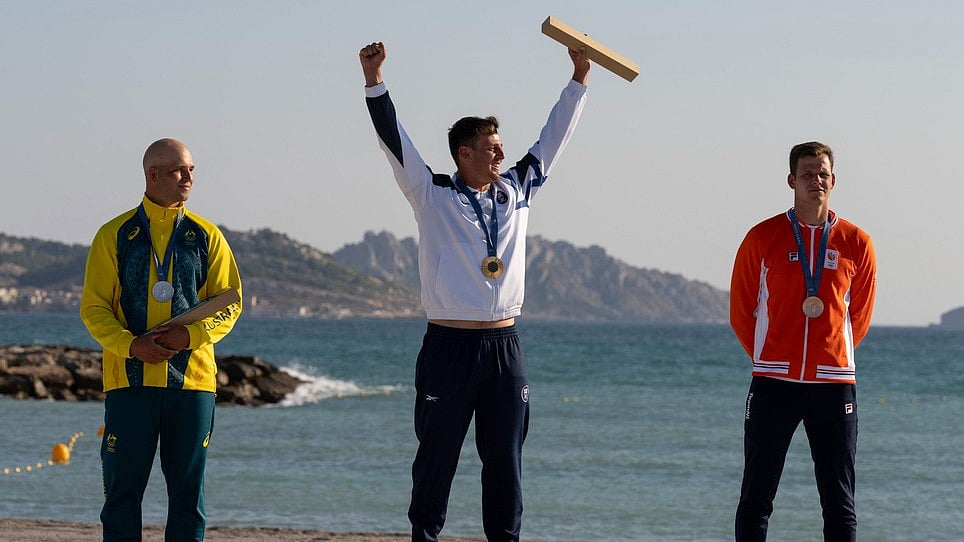 AP : Tom Reuveny of Israel, joined by Grae Morris of Australia, who won the silver medal, and Luuc van Opzeeland of the Netherlands, who won the bronze medal, celebrates winning the men's iQFOiL windsurfing gold medal during an Olympic medal ceremony during the 2024 Summer Olympics, Saturday, Aug. 3, 2024, in Marseille, France.
