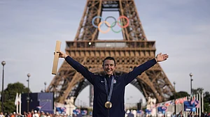 AP/Thibault Camus : Kristen Faulkner, of the United States, poses with the gold medal of the women's road cycling event, at the 2024 Summer Olympics, Sunday, Aug. 4, 2024, in Paris, France.