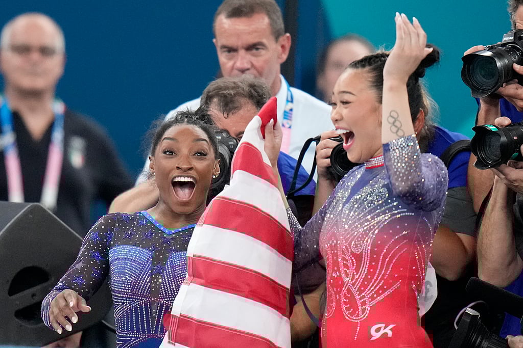 (AP Photo/Natacha Pisarenko) : Simone Biles, left, celebrates with teammate Suni Lee, of the United States, after winning the gold and bronze medals respectively in the women's artistic gymnastics all-around finals in Bercy Arena at the 2024 Summer Olympics, Thursday, Aug. 1, 2024, in Paris, France.