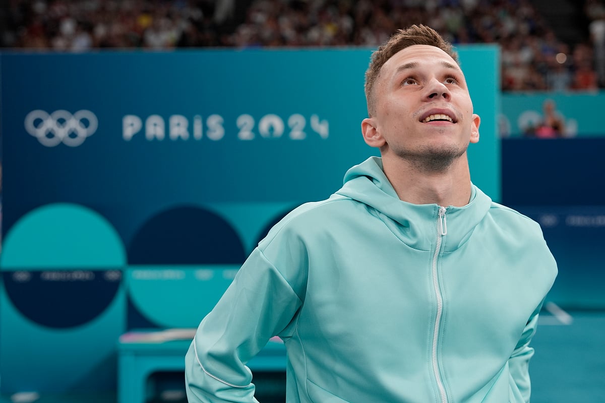 (AP PhotoCharlie Riedel) : Ivan Litvinovich of the Individual Neutral Athletes watches scores after winning the gold medal during the men's trampoline finals in Bercy Arena at the 2024 Summer Olympics, Friday, Aug. 2, 2024, in Paris, France. 
