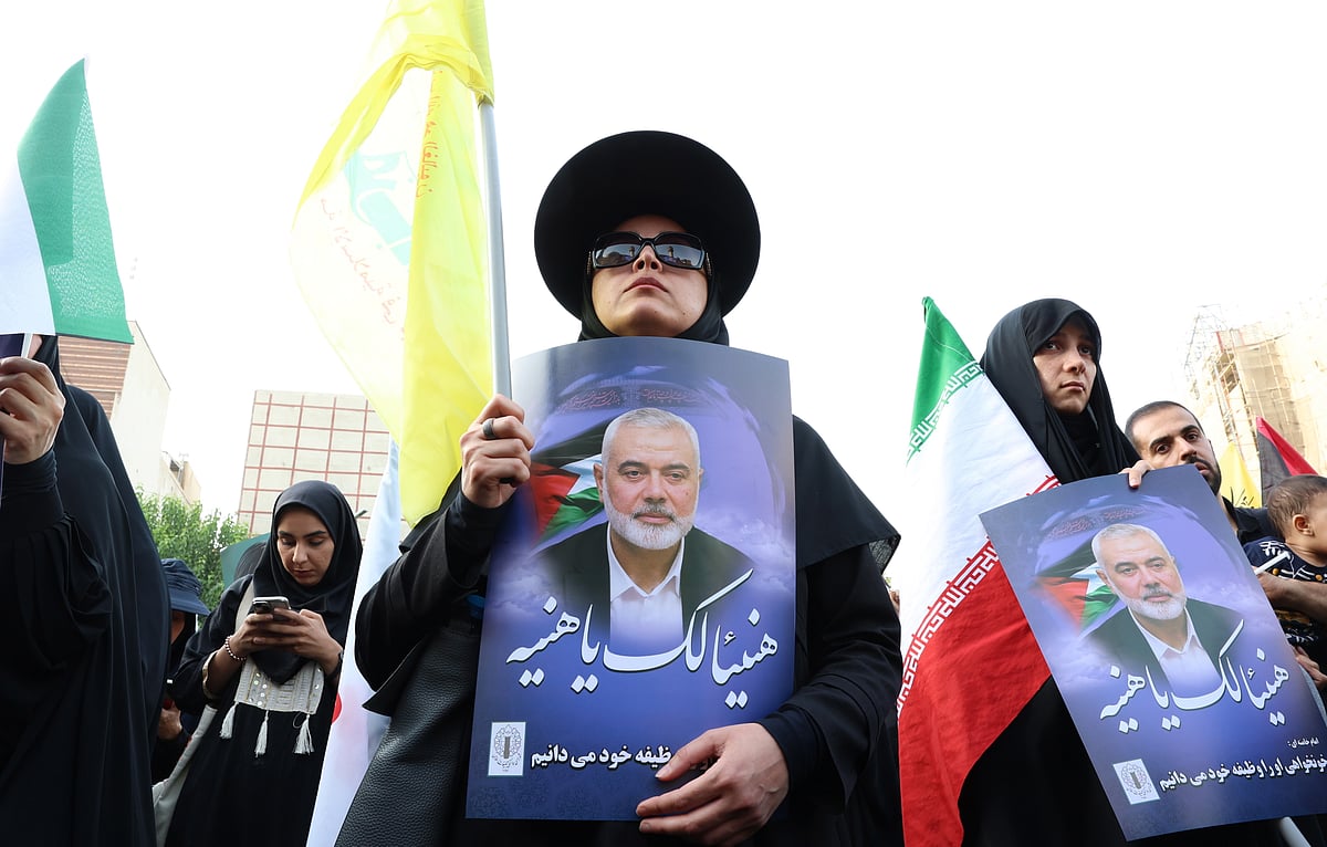 Iranians hold pictures of late Hamas Leader Ismail Haniyeh during a protest - PTI