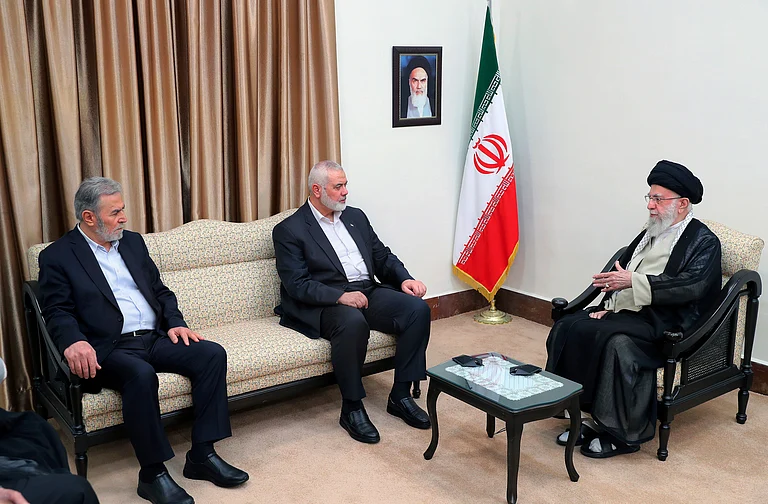 In this photo released by the office of the Iranian supreme leader, Supreme Leader Ayatollah Ali Khamenei, right, speaks with Hamas chief Ismail Haniyeh, center, and the leader of the Palestinian Islamic Jihad group Ziad Nakhaleh in their meeting in Tehran, Iran, Tuesday, July 30, 2024. A portrait of the late Iranian revolutionary founder Ayatollah Khomeini hangs on the wall. -  (Office of the Iranian Supreme Leader via AP)
