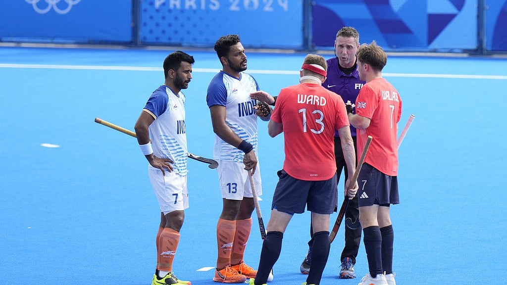 India captain Harmanpreet Singh (second left) watches as the umpire Sean Rapaport speaks to Britain's Sam Ward (13) during the men's quarter-final hockey match at the Paris Olympics on Sunday (August 4). - AP
