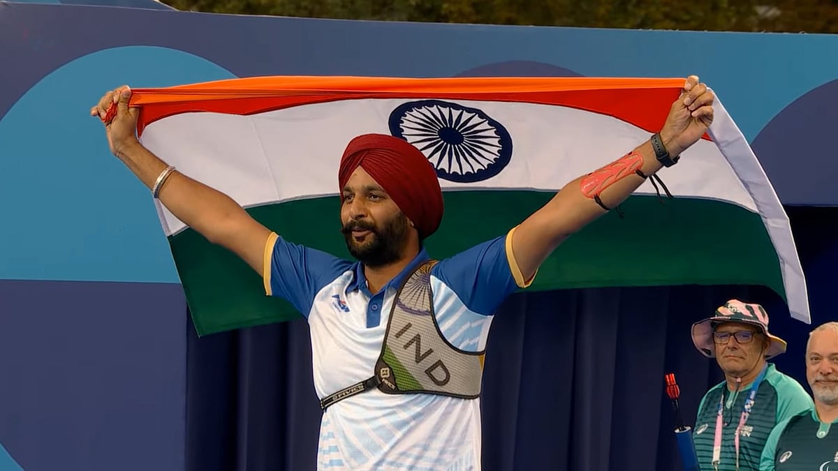 X : Harvinder Singh, India's Gold medallist, poses with the flag