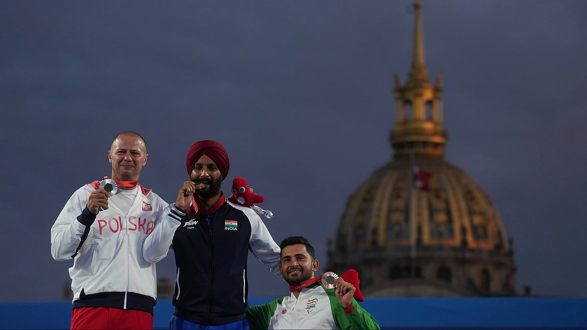 AP/PTI : Harvinder Singh of India, center, Lukasz Ciszek of Poland, left, and Mohammad Reza Arab Amiri of Iran celebrate on the podium after the men's Individual Recurve Open, during the 2024 Paralympics, Wednesday, Sept. 4, 2024, in Paris, France.