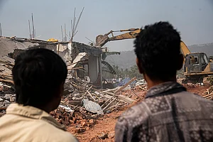 via Getty Images : Bulldozer being used to demolish alleged illegal structures during an anti-encroachment eviction drive by Guwahati