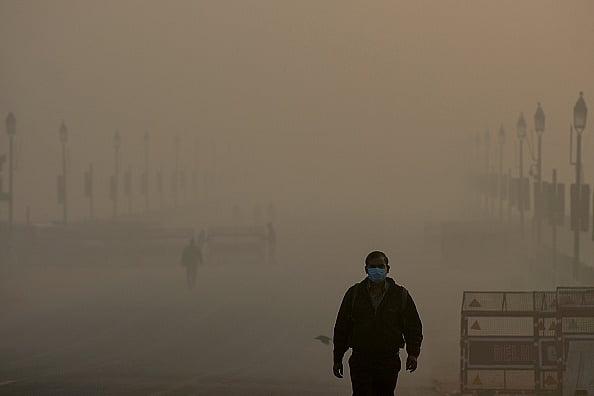 via Getty Images : People near India Gate in the early hours of a smoggy morning at Rajpath