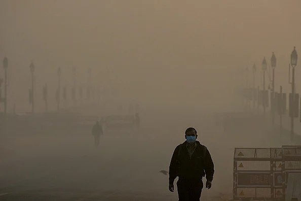 People near India Gate in the early hours of a smoggy morning at Rajpath
