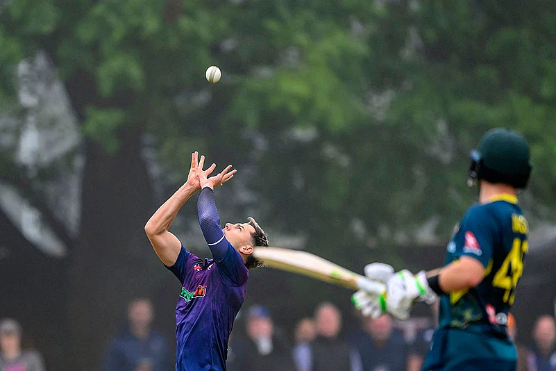 Bradley Currie of Scotland catches the ball to claim the wicket of Cameron Green of Australia